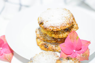 Zuckerfreie Erdmandel Kekse auf einem weißen Dessertteller. Im Hintergrund sieht man eine rosa Blüte und ein Geschirrtuch.